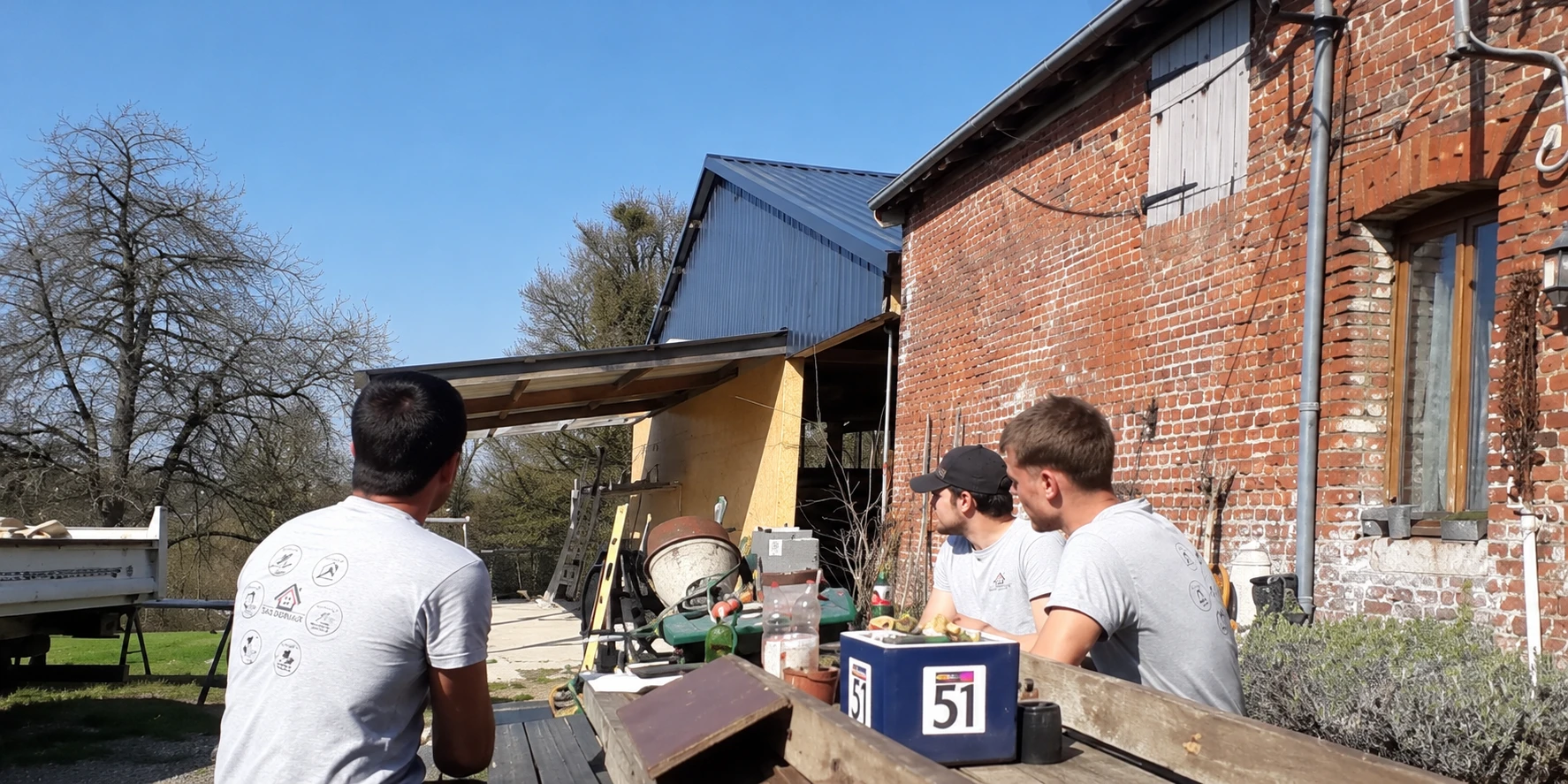 L’équipe SAS DERVAUX réunie devant un bâtiment en briques