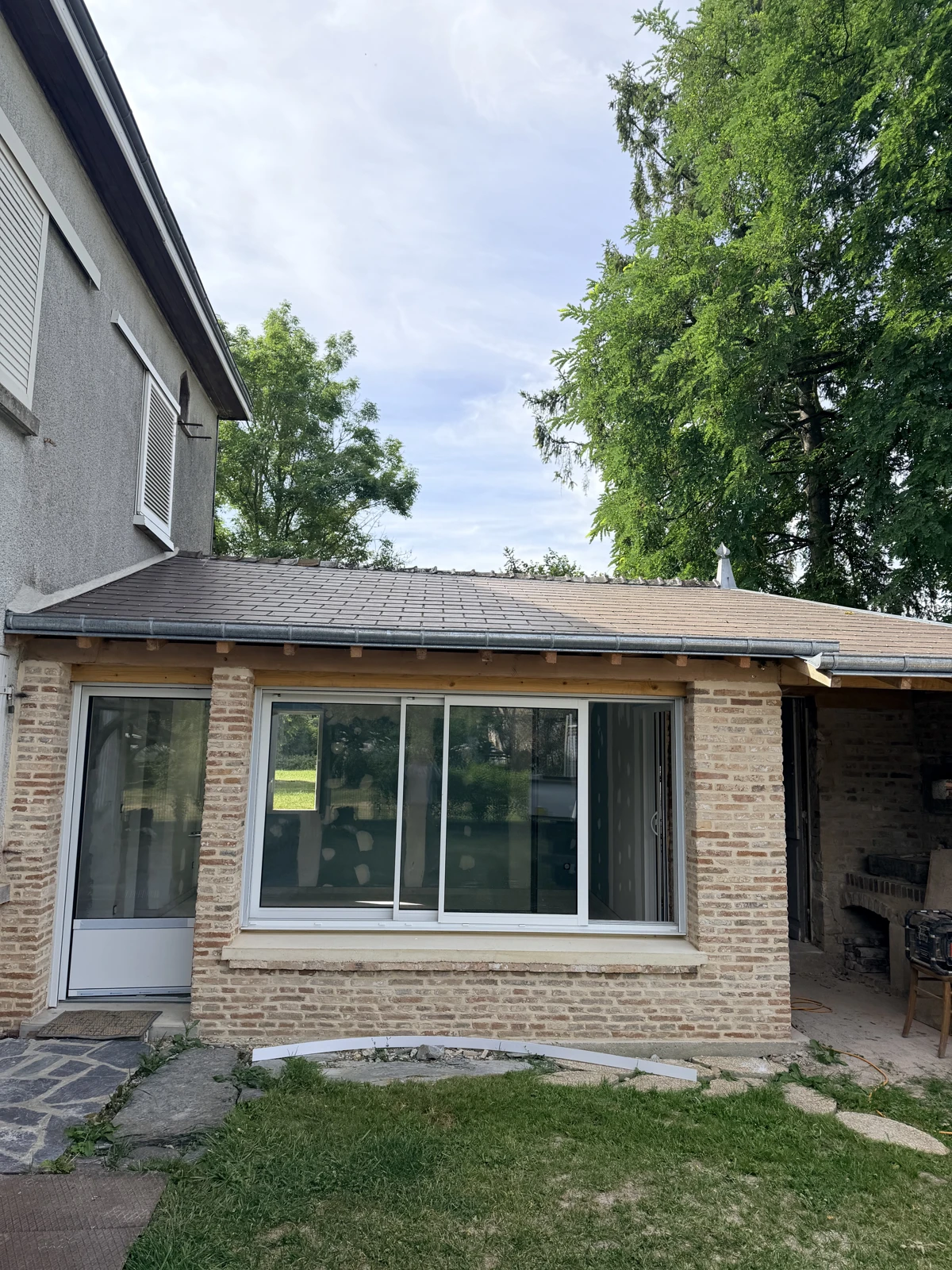 Extension avec façade en briques, porte et baie vitrée installées — SAS DERVAUX